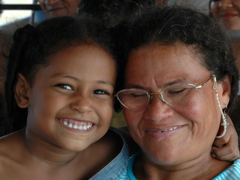 Young girl and an older woman smiling cheek to cheek