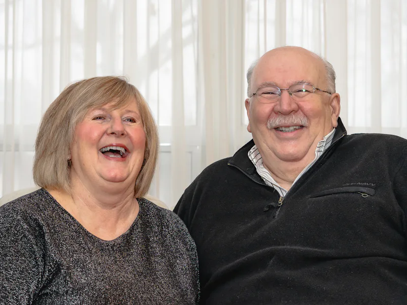 Older couple laughing together at home