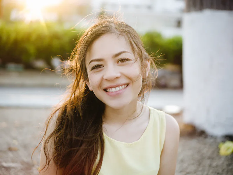 Teenage girl smiling outdoors in the sunshine